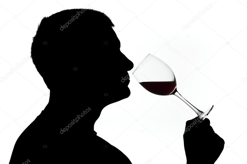 A man in silhouette smelling wine