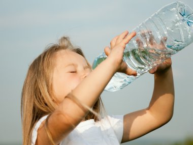 Kid drinking water from a bottle clipart