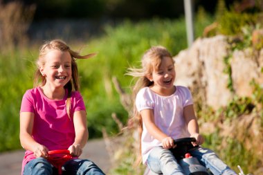 Two sisters with toy cars clipart