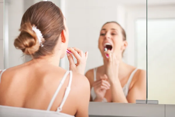 Ung kvinna borsta tänderna på tvätt skål — Stockfoto