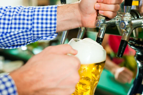 Mann zieht Bier aus Zapfhahn — Stockfoto
