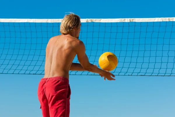 Мужчина играет в пляжный волейбол — стоковое фото