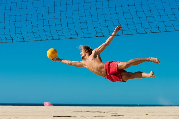 Мужчина играет в пляжный волейбол — стоковое фото