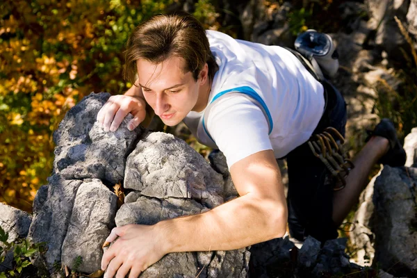 Homem escalando uma rocha curta — Fotografia de Stock