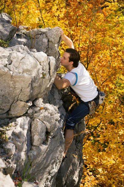 Homem escalando uma rocha curta — Fotografia de Stock