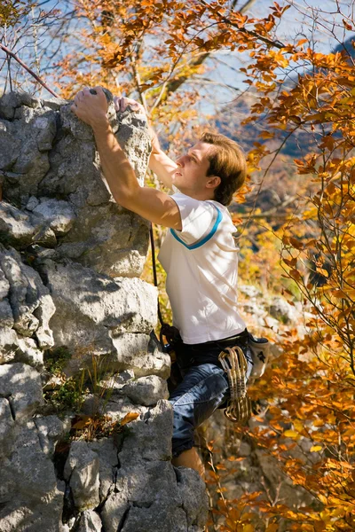 Mann klettert einen Felsen hinauf — Stockfoto