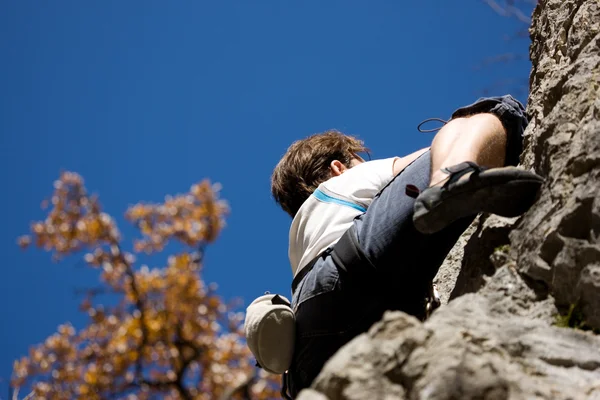 Человек залезает на скалу — стоковое фото