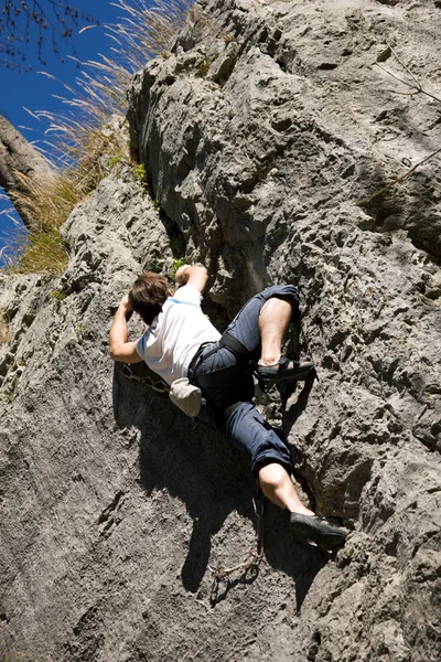 Mann klettert einen Felsen hinauf — Stockfoto