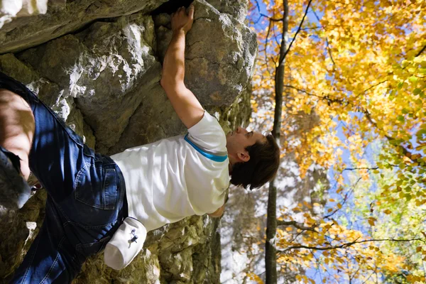 Uomo che scala una roccia corta — Foto Stock