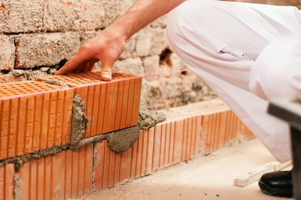 Bricklayer laying bricks to make — Stock Photo, Image