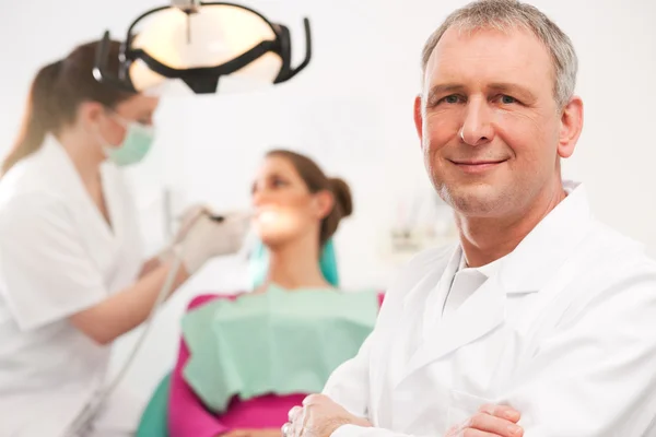 Dentista em sua cirurgia olhando para — Fotografia de Stock