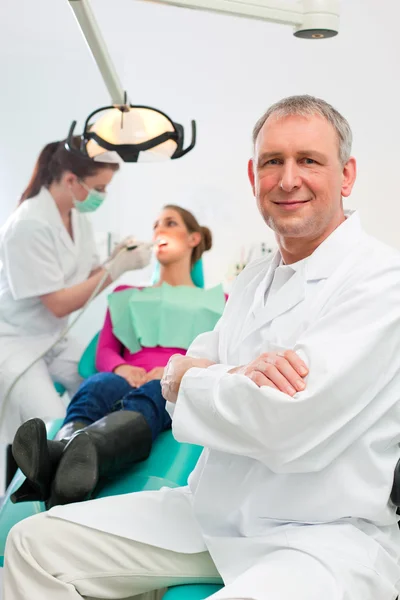 Dentist in his surgery looking at — Stock Photo, Image