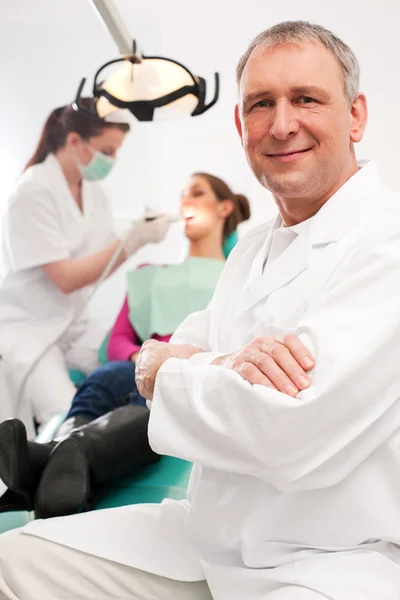 Dentist in his surgery looking at — Stock Photo, Image