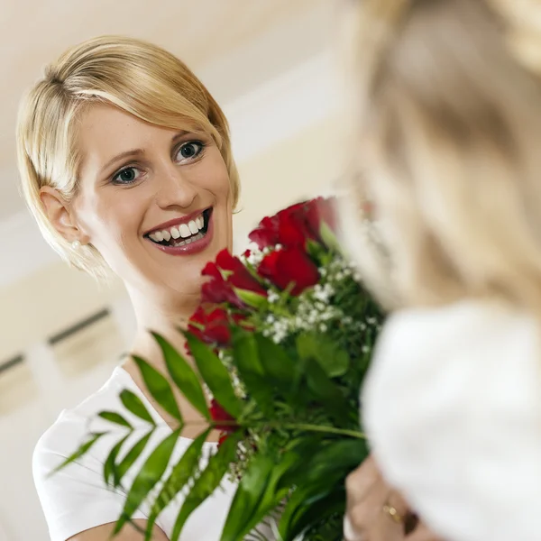 Girl child giving flowers to her — Stock Photo, Image