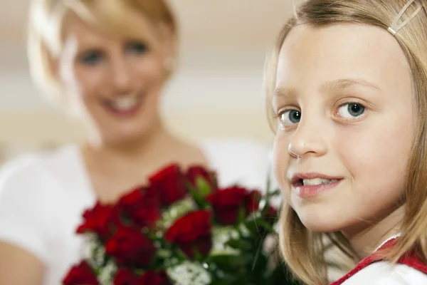 Dívka dítě dát jí květiny — Stock fotografie