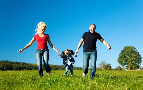 Familia activa corriendo por una — Foto de Stock