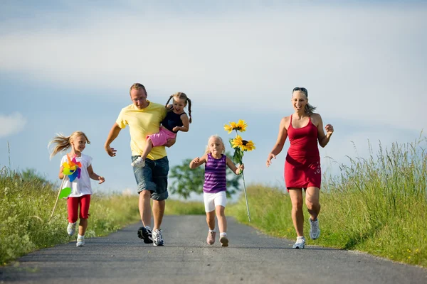 Сім'я з трьома дітьми біжить — стокове фото