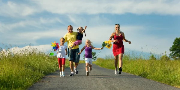 Сім'я з трьома дітьми біжить — стокове фото