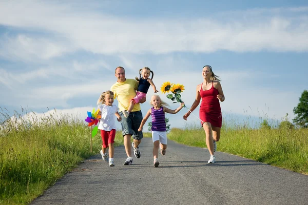 Family with three kids running — Stock Photo, Image