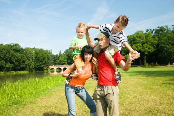 Family in the grass at a — Stock Photo, Image