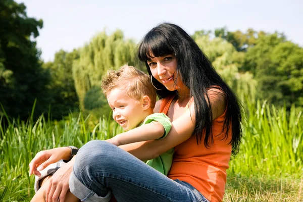 Family in the grass at a — Stock Photo, Image