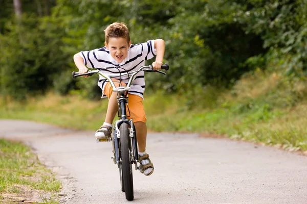 Kleine jongen rijden zijn fiets op een — Stockfoto