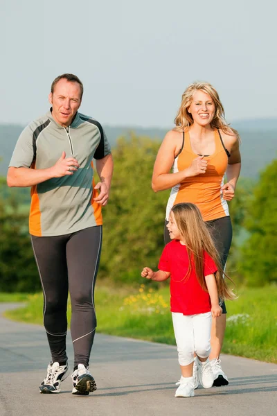 Familia corriendo al aire libre con — Foto de Stock