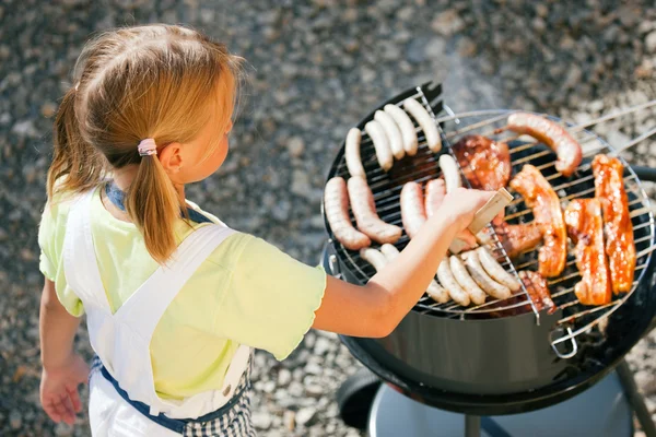 Kleines Mädchen bereitet Fleisch zu und — Stockfoto