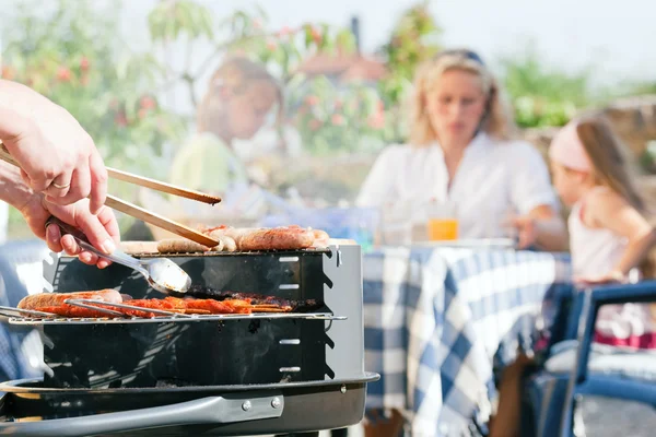 Familie met een barbecue in de — Stockfoto