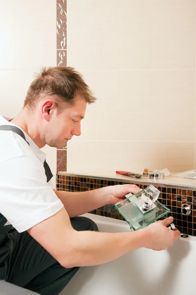 Plombier installant un robinet mélangeur dans — Photo