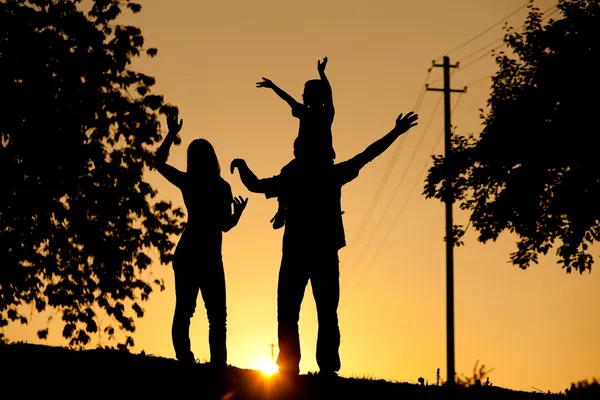 Семья, гуляющая на закате — стоковое фото