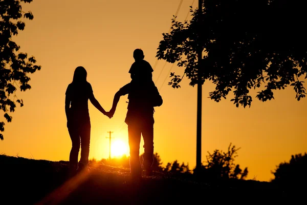 Family having a walk at sunset — Stock Photo, Image