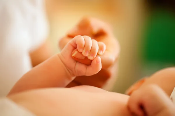Baby grijpen van de hand van haar — Stockfoto