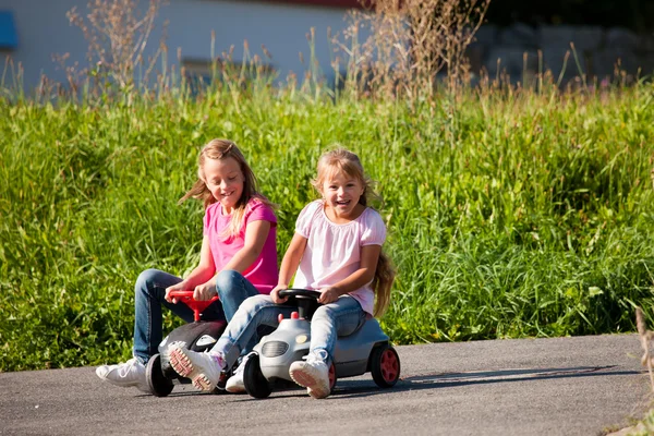 Oyuncak arabalar ile iki kız kardeş — Stok fotoğraf