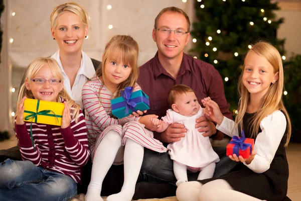 Οικογένεια μπροστά από ένα χριστουγεννιάτικο δέντρο — Φωτογραφία Αρχείου