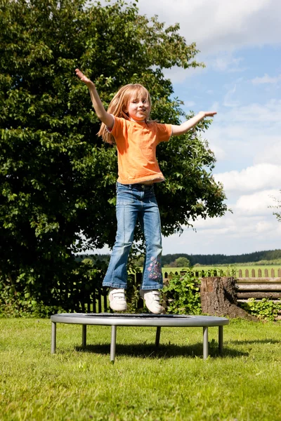 Kleines Mädchen auf einem Trampolin in einem — Stockfoto
