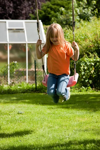 Little girl child sitting on a swing — Stock Photo, Image