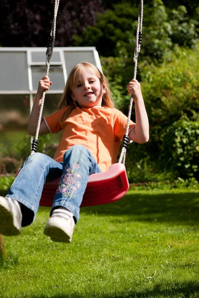 Little girl child sitting on a swing — Stock Photo, Image