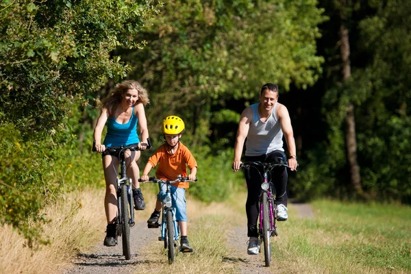 Familj med barn på sina cyklar — Stockfoto