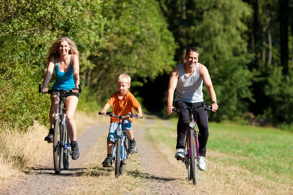 Семья с ребенком на велосипедах — стоковое фото