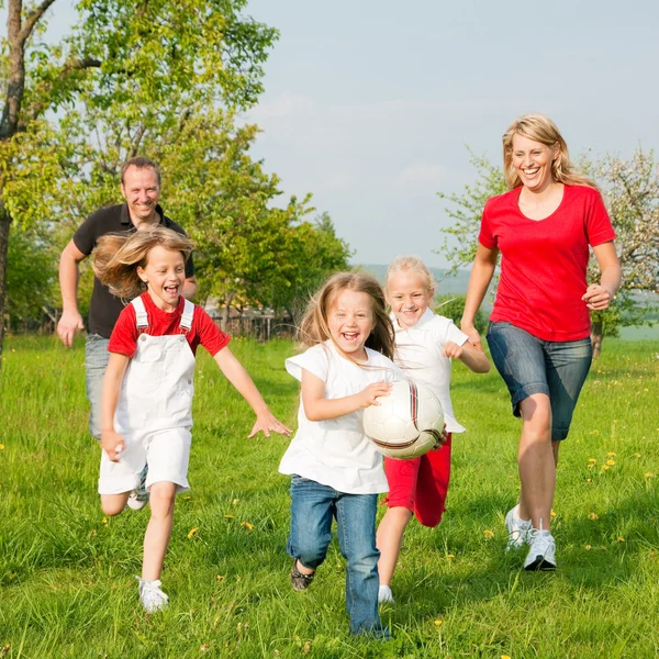 Glückliche Familie spielt Fußball Stockbild