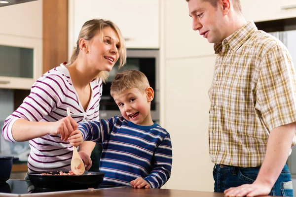 Familjen matlagning i deras kök Stockfoto