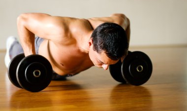 Strong man with dumbbells clipart