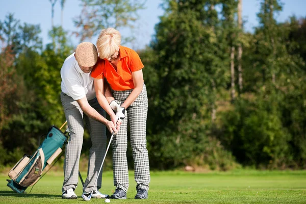 Starší pár, hrát golf na — Stock fotografie