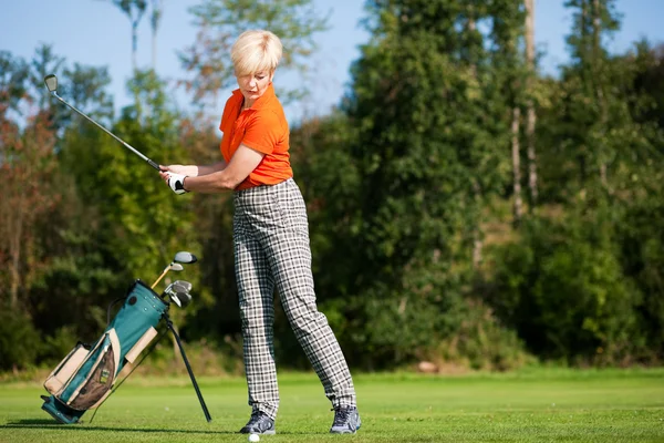 Senior női golfer csinál egy — Stock Fotó