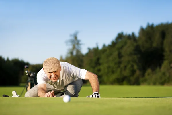 Äldre man spelar golf som syftar — Stockfoto