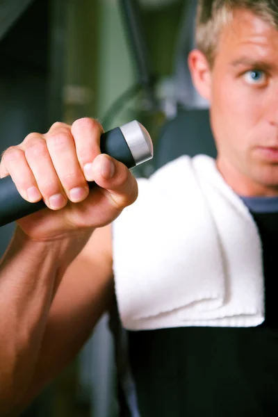 Strong man lifting dumbbells in — Stock Photo, Image