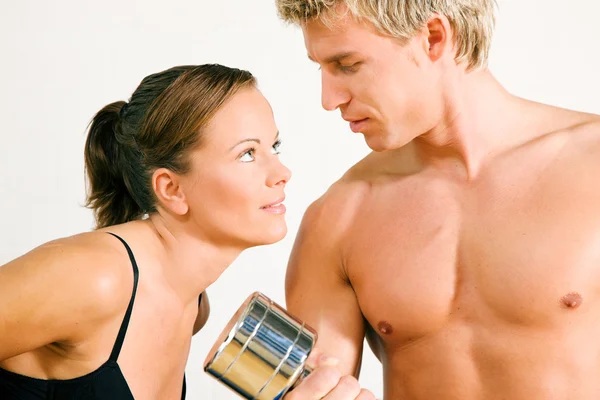 Couple in gym setting. He is — Stock Photo, Image