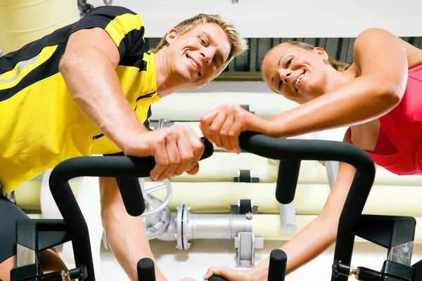 Couple exercising by spinning — Stock Photo, Image