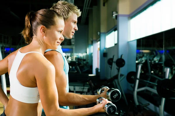 Paar im Fitnessstudio, die sich gegenseitig Konkurrenz machen — Stockfoto